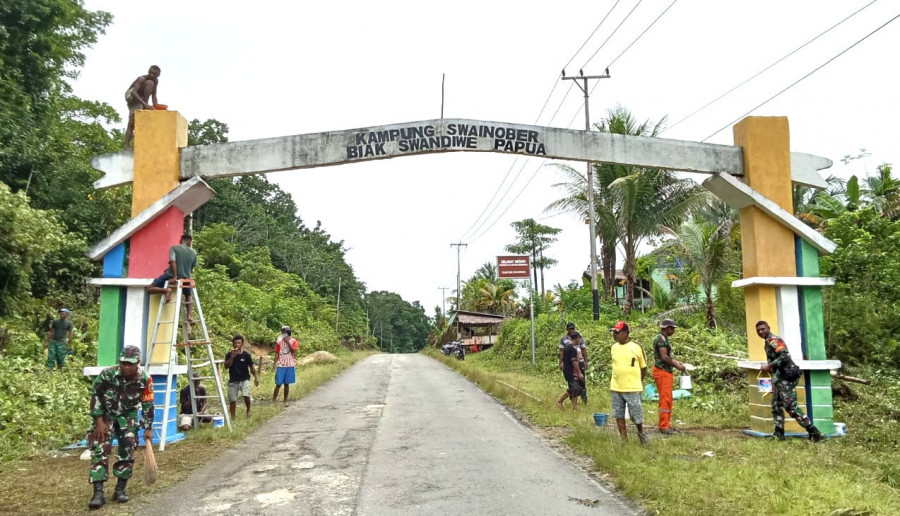 Manunggal dengan Rakyat, Babinsa Biak Barat Bantu Pengecatan Gapura